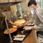 Student selecting pizza at the North Avenue Dining Hall