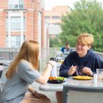 Students dining on the balcony at the West Village Dining Commons