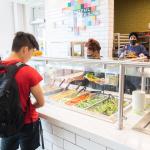 student selecting food at the West Village Dining Commons