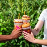 group of people holding dunkin cold drinks in hand