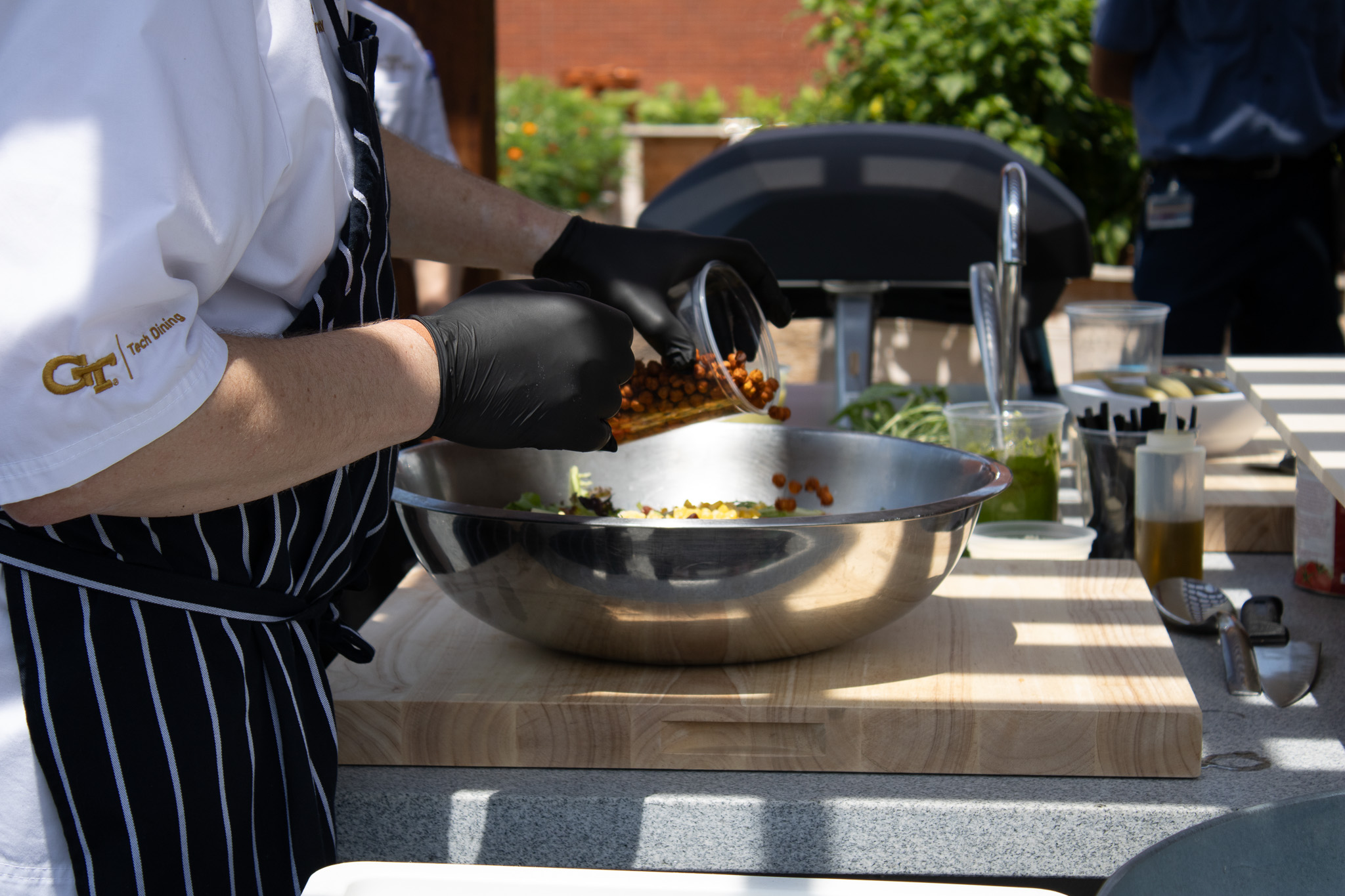 Chefs mixing ingredients in a stainless steel bowl