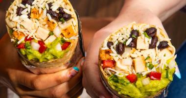 Two hands holding burritos