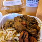 Curry chicken w/ sides of cabbage, a couple fried plantains, and peas & rice. Pineapple ginger juice, and the famous coconut rum cake